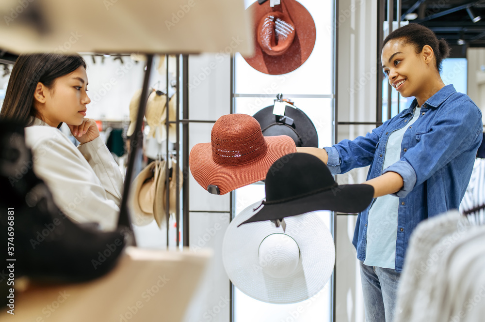 Sticker Two girls choosing hats in clothing store