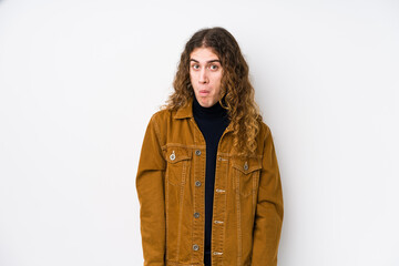 Long hair man posing isolated shrugs shoulders and open eyes confused.