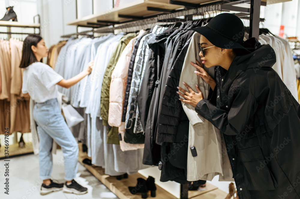 Canvas Prints two cute girls buying clothes in clothing store