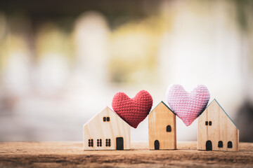 Wooden house model and heart put on the wood on sunlight in the public park, The buying a new real...