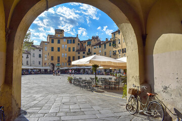 Piazza dell'Anfiteatro di Lucca, vista da una delle porte di ingresso. - obrazy, fototapety, plakaty