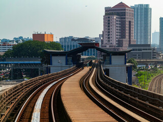 Naklejka premium Going to work by train under a bright sunny sunrise with the cityscape and building at the horizon