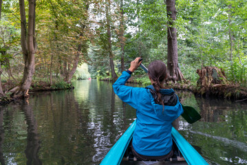 Fototapeta na wymiar female kayaker enjoys paddling through the channels and canals o the Spreewald region in Germany