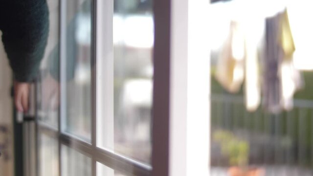 young man opening balcony sliding window door