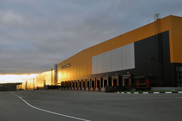 Fototapeta na wymiar Warehouse logistics complex in the rays of the rising sun.