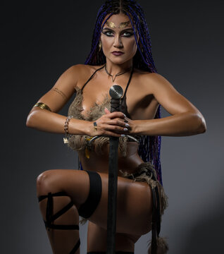 Beautiful horsewoman in nice bicini with a sword