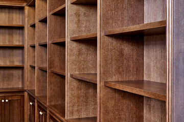Wooden bookcase with empty shelves in home library
