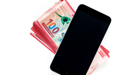 Bolivian currency, One hundred Bolivianos banknotes lying together with a mobile phone on a white background, Place for text