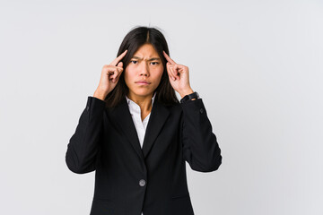 Young asian business woman focused on a task, keeping forefingers pointing head.