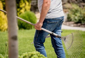 Professional gardener goes to cut trees with garden scissors and rake