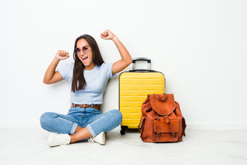 Young mixed race indian woman ready to go to travel celebrating a special day, jumps and raise arms...