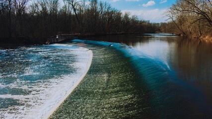 Fast Flowing Water Crashing Over a Man-Made Dam in a Winter Forest