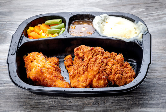 Fried chicken and potatoes TV dinner served in a tray