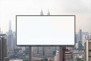 Blank white road billboard with KL cityscape background at day time. Street advertising poster, mock up, 3D rendering. Front view. The concept of marketing communication to promote or sell idea.