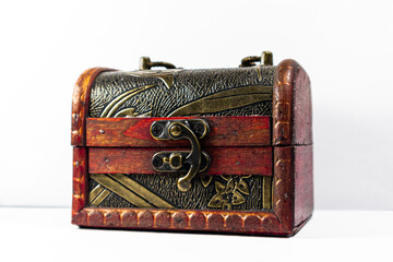 Old and vintage pirate chest on a white isolated background. Red and golden treasure chest locked down.