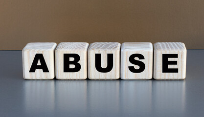 Obraz premium ABUSE - word on cubes on a beautiful coffee background