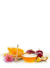 Honey, red apples and flower on white table on the white background with space for text