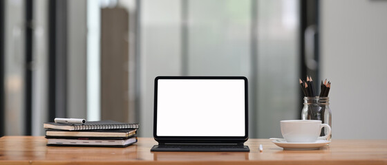 A computer tablet with a keyboard case is putting on workspace.