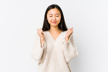 Young chinese woman isolated raising fist, feeling happy and successful. Victory concept.