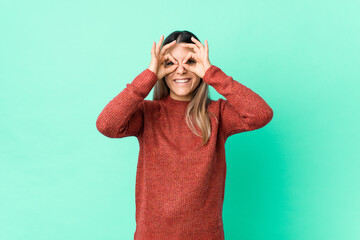 Naklejka premium Young caucasian woman isolated showing okay sign over eyes