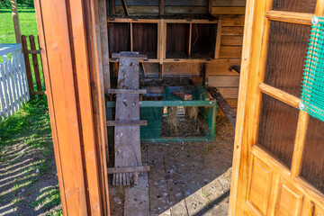 Fototapeta na wymiar Interior of a wooden henhouse in the countryside seen through an open door.