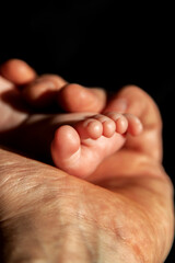 Father hand holding a baby foot