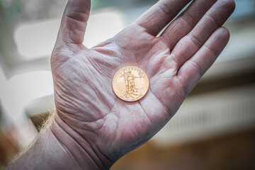 Gold Coin Held in Hand