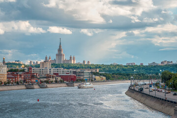 Fototapeta premium Beautiful Moscow evening cityscape. University on a green hill in the evening sun