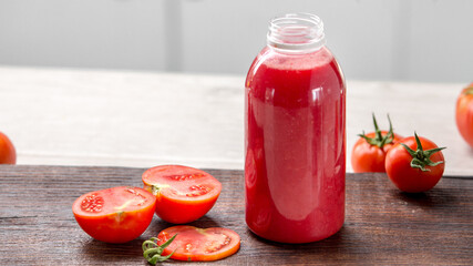 Tomatoes on white kitchen and tomato juice with green tomato leaves. Home grown tomatoes 