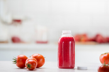 Tomatoes on white kitchen and tomato juice with green tomato leaves. Home grown tomatoes 