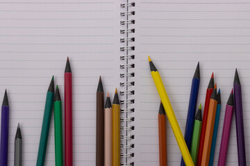 Top view multicolor blackwood pencils are laid out on a spiral notebook. Back to school. Copy space