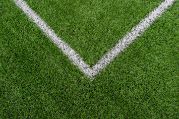 Green synthetic grass sports field with white line shot from above. Soccer, rugby, football, baseball sport concept