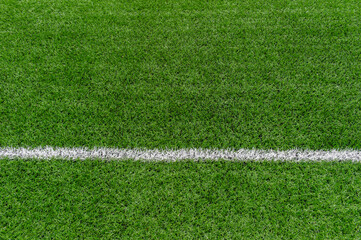 Fototapeta premium Green synthetic grass sports field with white line shot from above. Soccer, rugby, football, baseball sport concept