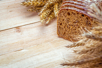 Rustic bread. Fresh loaf of rustic traditional bread with wheat grain ear or spike plant on wooden...