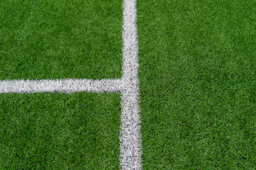 Green synthetic grass sports field with white line shot from above. Soccer, rugby, football, baseball sport concept