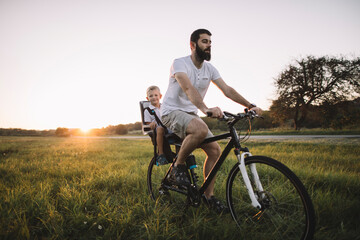 Father and his son cycling together outdoors, copy space