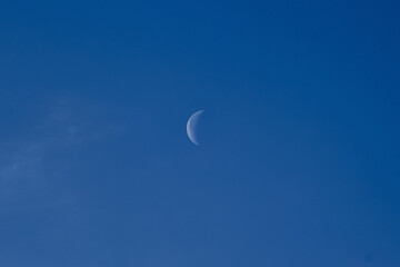 day moon against a blue sky with Cirrus Cumulus clouds