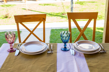 
Banquet table setting with white plates, glass glasses.