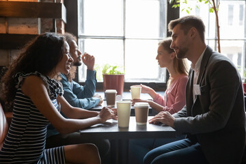 Diverse people sitting in cafe, drinking coffee and talking, chatting, participating in speed dating, young men and women having fun at meeting in coffee house, getting acquaintance - obrazy, fototapety, plakaty