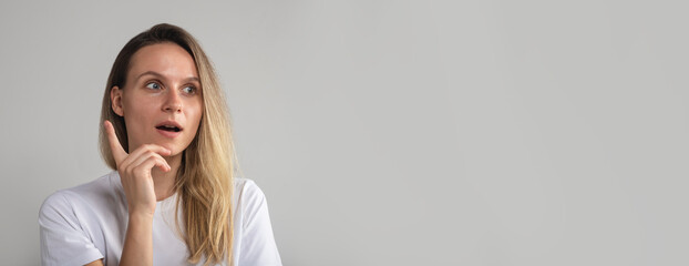 surprised shocked exhilarated young woman with raised index finger coming up with idea. Woman...