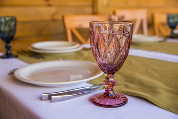 Banquet table setting with white plates, glass glasses.