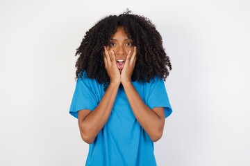 Fototapeta na wymiar Studio shot of scared terrified Young african woman with curly hair wearing casual blue shirt shocked with prices at shop, being short of money to buy something, People and human emotions concept