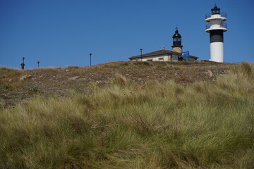 Fototapeta na wymiar Lighthouse in San Cibrao San Ciprian, coastal village of Galicia, Spain