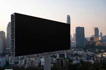 Blank black road billboard with Bangkok cityscape background at sunset. Street advertising poster, mock up, 3D rendering. Side view. The concept of marketing communication to promote or sell idea.