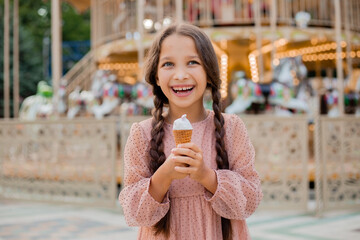 Teenage girl with dark hair and pigtails with ice cream at amusement park
