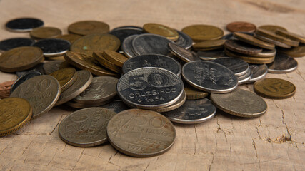 Old coins placed on a rustic wooden platform, selective focus