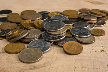 Old coins placed on a rustic wooden platform, selective focus