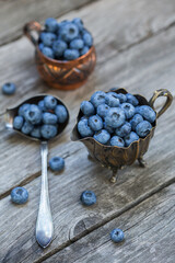 Blueberry berries on an old wooden background, vintage style photo.