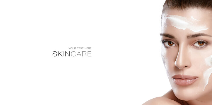 Beauty and skincare concept. Beautiful natural young woman face with cream on a healthy fresh clean skin.
