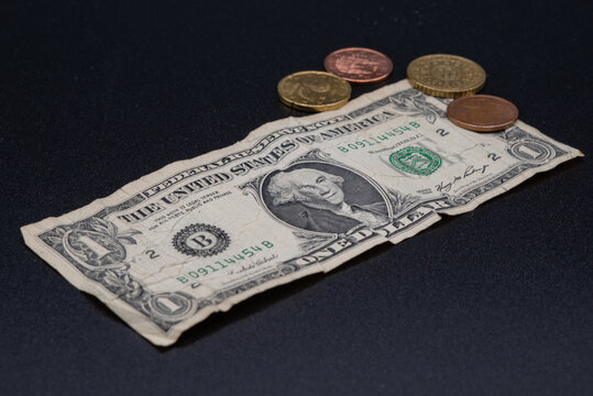 Un billete de un d&oacute;lar con varias monedas de euro